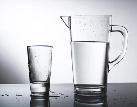 A glass and a pitcher of water.